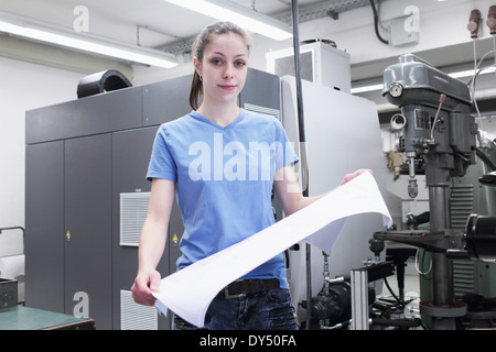 Portrait of female engineer holding blueprint Stock Photo