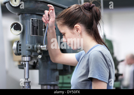 Female engineer using machine in workshop Stock Photo