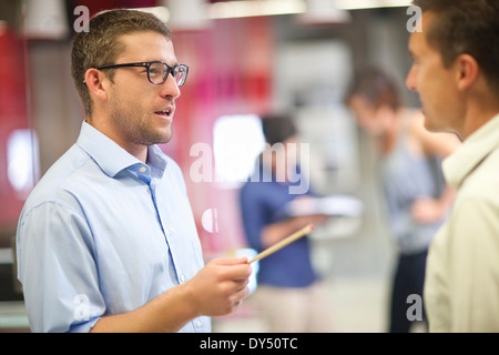 Young businessman discussing ideas with colleague Stock Photo