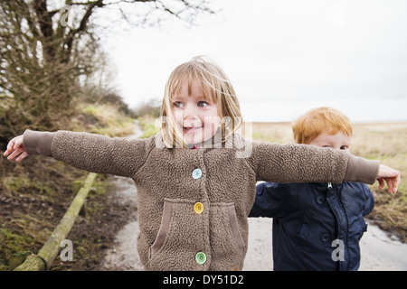 Young sister and brother playing on rural road Stock Photo