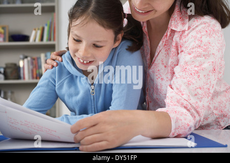 Mother helping young daughter with homework Stock Photo