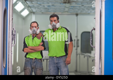 Portrait of carpenters in spray painting workshop doorway Stock Photo