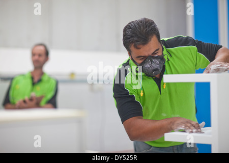 Man sanding wood products in carpenters workshop Stock Photo