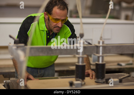 Carpenter cutting wood on table saw in workshop Stock Photo