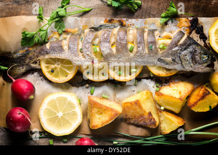 Prepared fish stuffed with lemon and spices on the table from above Stock Photo