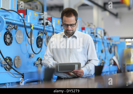 Technical manager checking information on digital tablet Stock Photo