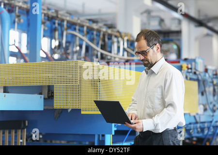 Technical manager checking information on laptop Stock Photo