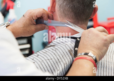Barber cutting man's hair Stock Photo