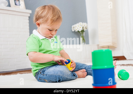 Baby boy playing with plastic toys Stock Photo