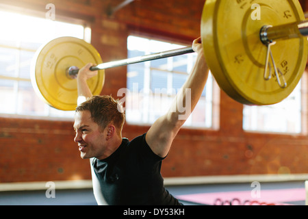 Man lifting weights in gymnasium Stock Photo