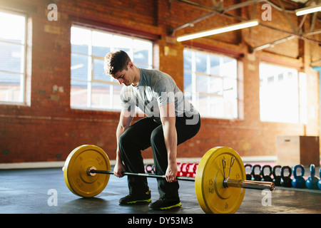 Man lifting weights in gymnasium Stock Photo