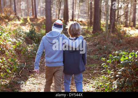 Twin brothers walking together in woods Stock Photo