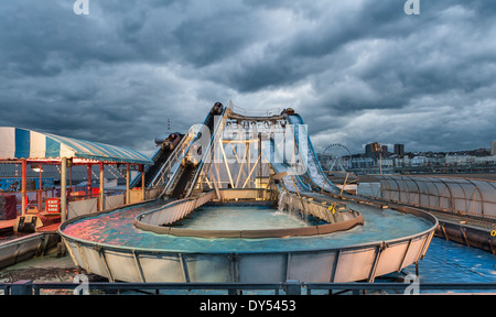 Funfair ride at night, on Brighton Pier, under a stormy sky (UK) Stock Photo