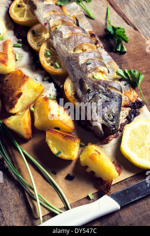 Prepared mackerel fish and baked potato.Selective focus on the fish head Stock Photo