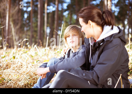 Mature woman taking a break with her son in a forest Stock Photo