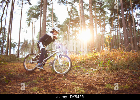 Boy riding his BMX through forest Stock Photo