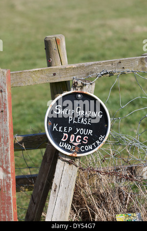 A sign in a field asking owners to keep their dogs under control. Stock Photo