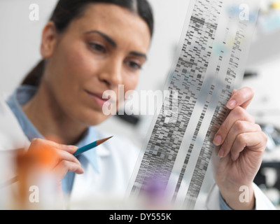 Female scientist examining DNA gel in laboratory for genetic research Stock Photo
