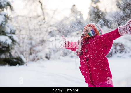 Young girl shouting and throwing snow mid air Stock Photo