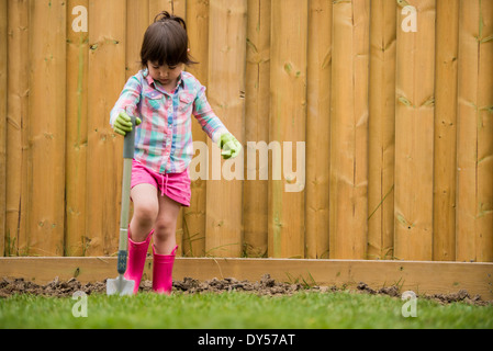 Young girl digging soil in the garden Stock Photo