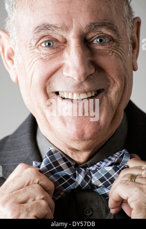 Senior man putting on bow tie Stock Photo