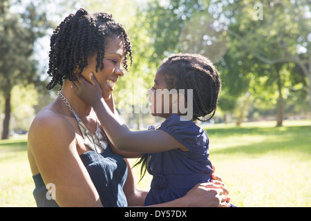 Mature woman carrying affectionate daughter in park Stock Photo