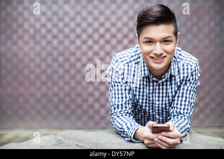 Portrait of young man holding smartphone Stock Photo