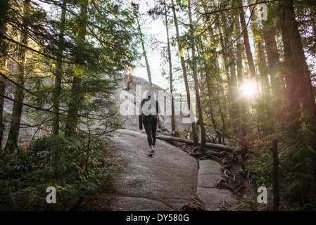 Young woman walking through forest, Squamish, British Columbia, Canada Stock Photo