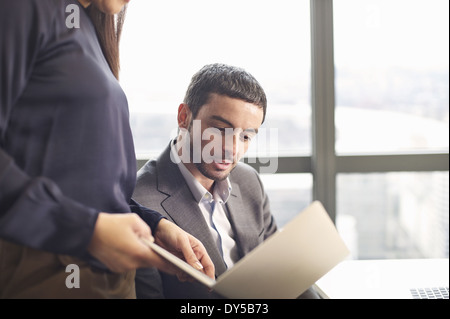 Business colleagues looking at ideas on laptop in office Stock Photo