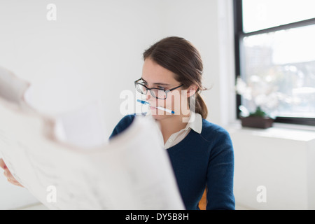 Young woman studying blueprint Stock Photo