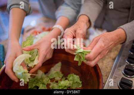 Senior woman and granddaughter preparing lettuce for salad Stock Photo