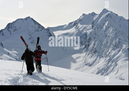 Two mid adult male skiers walking uphill, Obergurgl, Austria Stock Photo