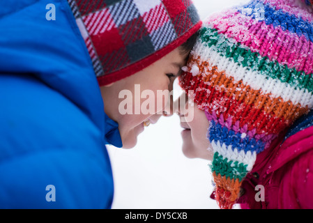 Brother and sister face to face in snow Stock Photo