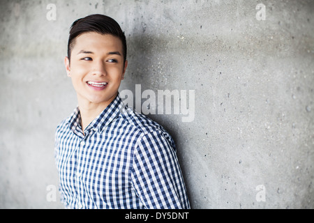 Portrait of young man leaning against wall Stock Photo