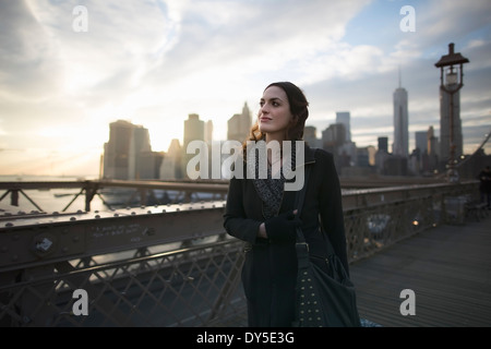 Young woman strolling on Brooklyn bridge, New York, USA