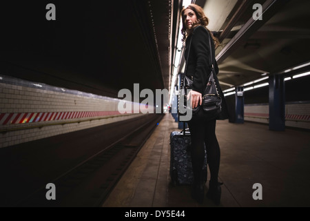 Young woman waiting in subway station, New York, USA