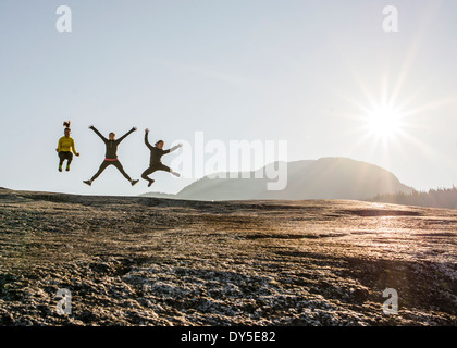 Three young female hikers jumping mid air on rock, Squamish, British Columbia, Canada Stock Photo
