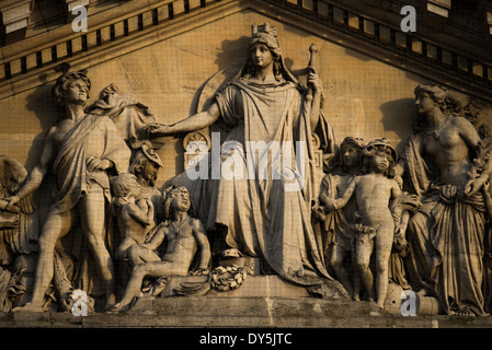 BRUSSELS, Belgium — An ornate pediment adorns the Brussels Stock Exchange building, exemplifying the elaborate architectural decoration of the 1868-1873 construction period. This sculptural element combines Neo-Renaissance and Second Empire styles, featuring work by renowned artists including the Jacquet brothers, Guillaume de Groot, Albert-Ernest Carrier-Belleuse, and Auguste Rodin. The pediment demonstrates the sophisticated architectural ornamentation of Belgium's 19th-century public buildings. Stock Photo