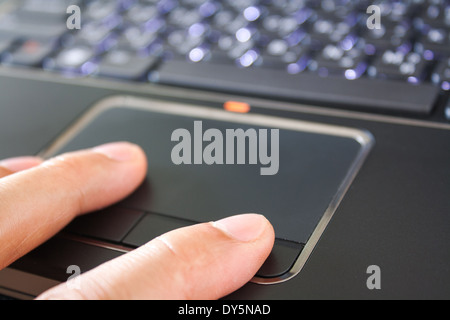a hand is touching the laptop touchpad Stock Photo