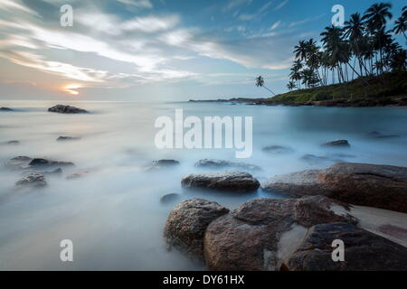 Sunrise at a secluded lagoon with rocks and palm trees framing the view, Tangalle, Sri Lanka, Indian Ocean, Asia Stock Photo