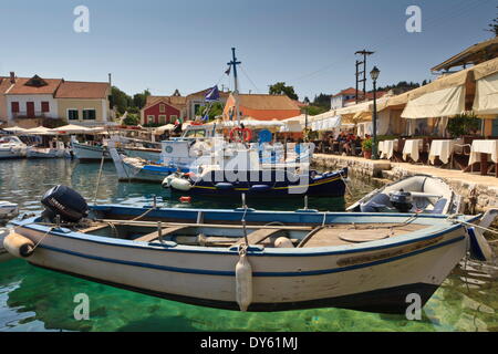 Harbourside with boats, cafes and clear green water, Fiskardo, Kefalonia (Cephalonia), Ionian Islands, Greece Stock Photo
