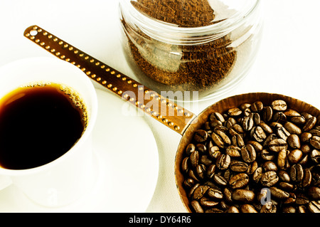 Coffee beans in an old copper pan. Ground coffee in a glass jar. Soluble coffee cup. Stock Photo