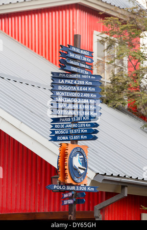 Signposts with distances to various world cities in the town of Ushuaia which is the capital of Tierra del Fuego, in Argentina, Stock Photo