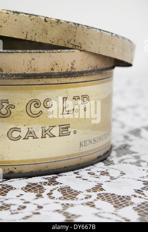 Vintage Cake Tin and flora tablecloth Stock Photo