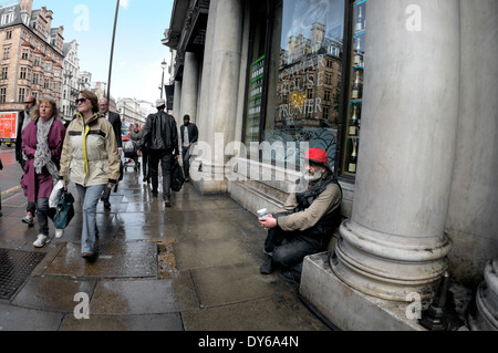 London, England, UK. Man begging on Piccadilly in front of the Caviar House Stock Photo