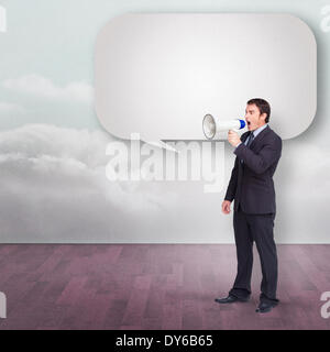 Standing businessman shouting through a megaphone with speech bubble Stock Photo