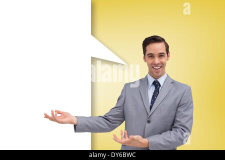 Composite image of young businessman presenting something  with speech bubble Stock Photo