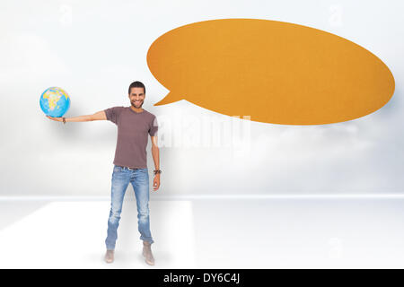 Composite image of handsome man with speech bubble holding out a globe Stock Photo