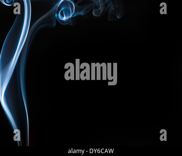 Flowing blue smoke frames a black backdrop Stock Photo
