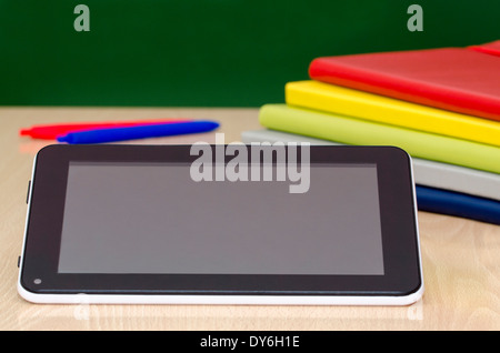 digital tablet leaning against a colorful notebooks,on a school desk Stock Photo
